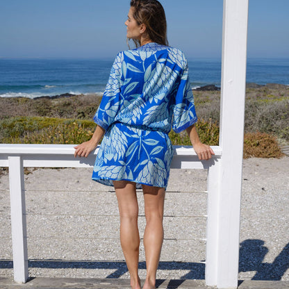Woman with short protea print kaftan cover up back facing