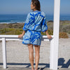 Woman with short protea print kaftan cover up back facing